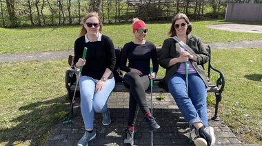 Drei Damen sitzen auf einer Bank am Minigolfplatz Bludenz und machen eine Pause zwischen dem Spiel. Die Sonne scheint. | © Dajana Baumgartner