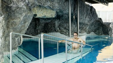 Ein Mann im Rollstuhl befindet sich im Wasser des Hallenbads im Hotel Val Blu. | © Val Blu