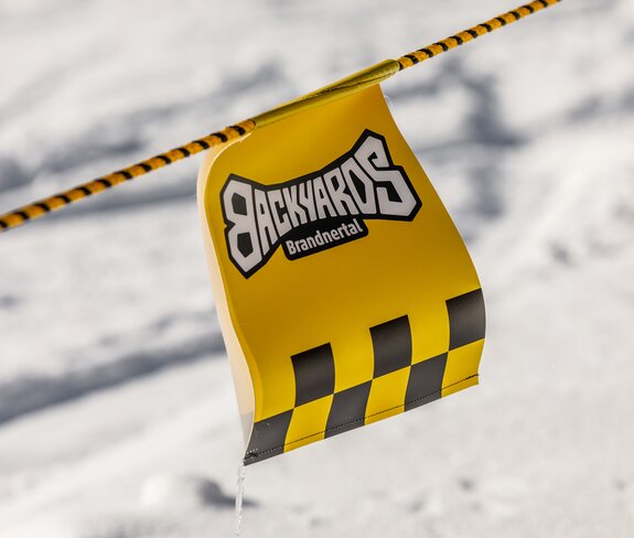 Ein Wimpel vom Backyards Brandnertal flattert im Wind. | © Bergbahnen Brandnertal, Roman Nöstler