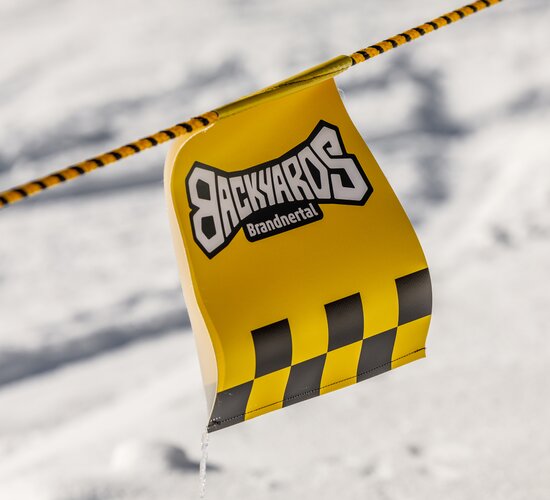 Ein Wimpel vom Backyards Brandnertal flattert im Wind. | © Bergbahnen Brandnertal, Roman Nöstler