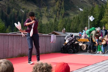 Jongleurin spielt mit weißen Kegeln. | © Bergbahnen Brandnertal, Bettina Schwarzhans