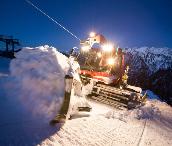 Der Kässbohrer mit Winde hängt am Windenseil und schiebt Schnee im Schild nach oben. | © Bergbahnen Brandnertal, Michael Marte