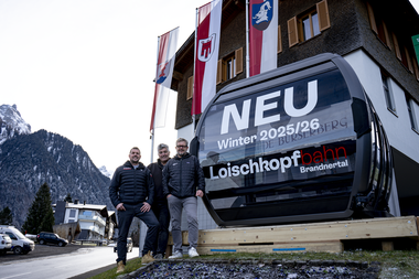 Die neue 10er Gondel der Loischkopfbahn steht vor dem Gemeindezentrum Bürserberg. Die Bürgermeister der Dörfer Brand und Bürserberg und der Geschäftsführer der Bergbahnen Brandnertal stehen vor der Gondel. | © Bergbahnen Brandnertal, Viviane Seils