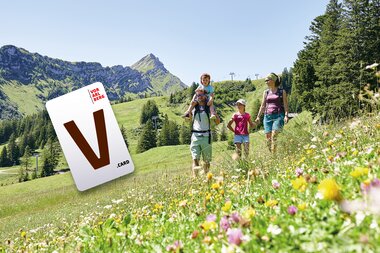 Das V-Card Ticket schwebt im Vordergrund. Daneben ist eine wandernde Familie zu sehen. | © V-Card Vorarlberg