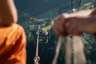 Zwei Gondeln werden durch ein Seil verbunden. Das Seil ist im Fokus des Bildes. | © Michael Kreyer
